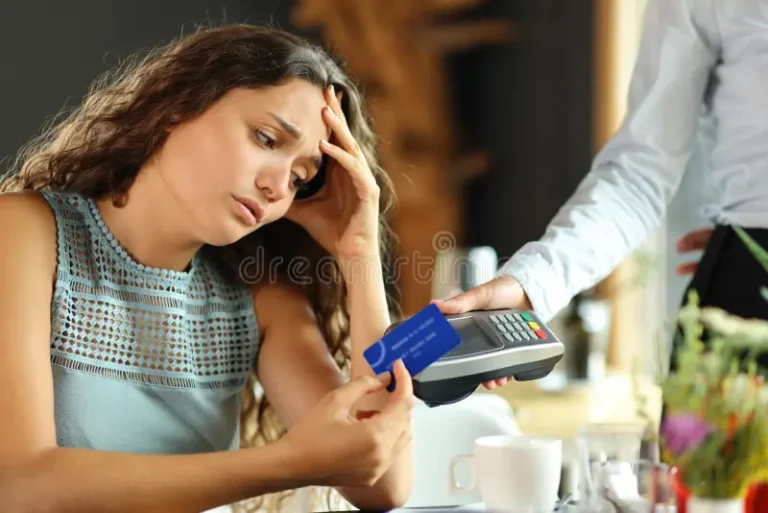 cliente preocupado pagando conta cara em um restaurante com cartão de crédito 259705882